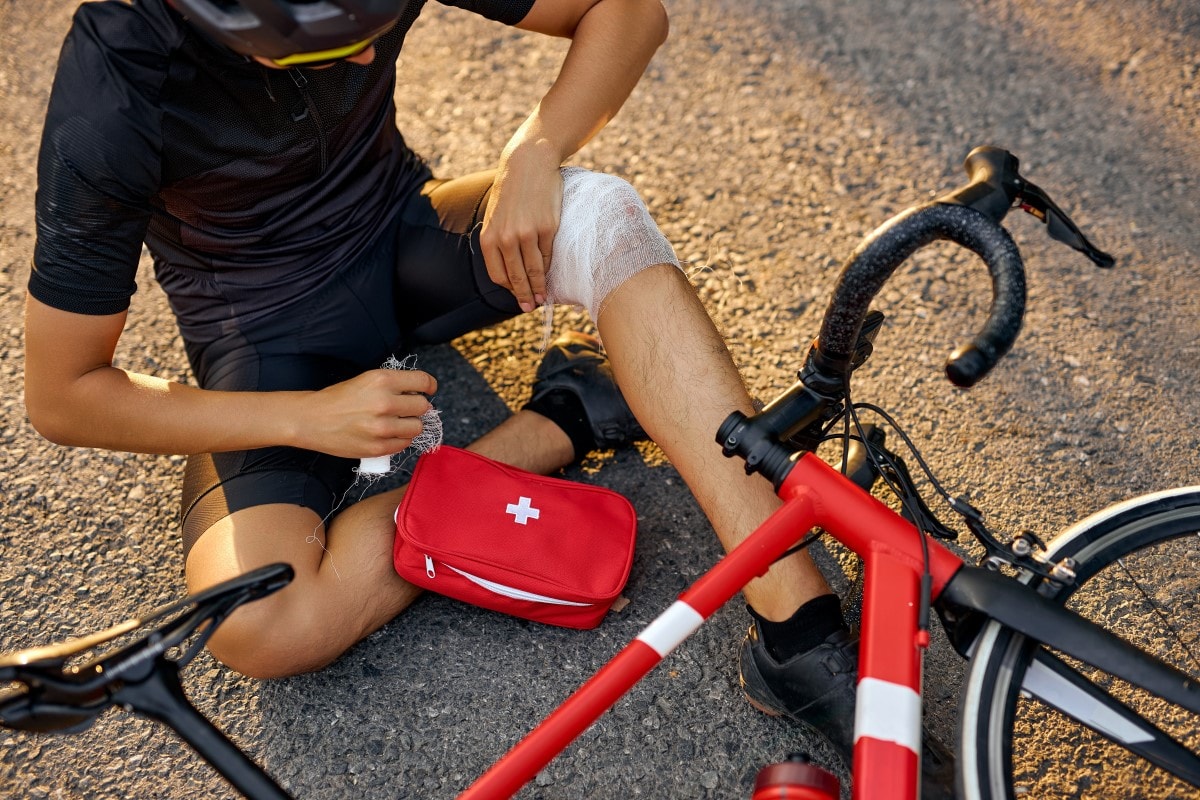 Gestürzter Radfahrer mit verbundenem Knie
