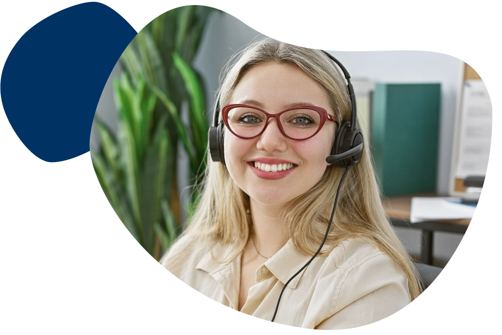 Frau sitzt im Büro mit einem Headset und lächelt freundlich.