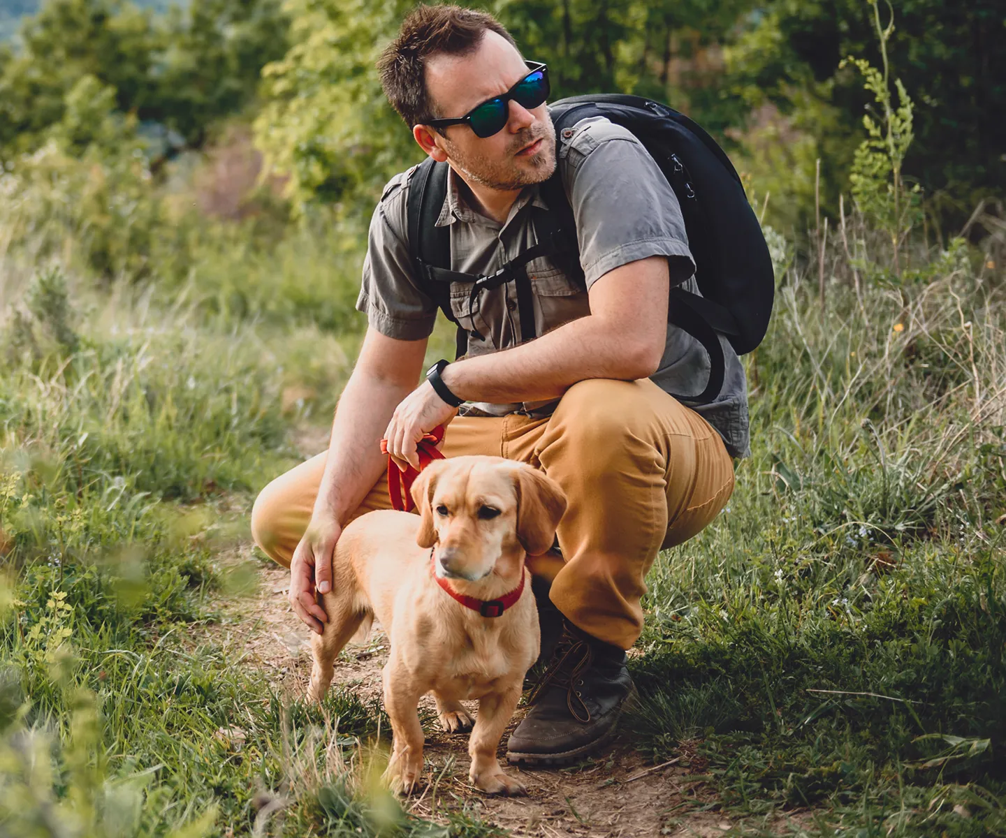 Mann und Hund auf einem Wanderweg.