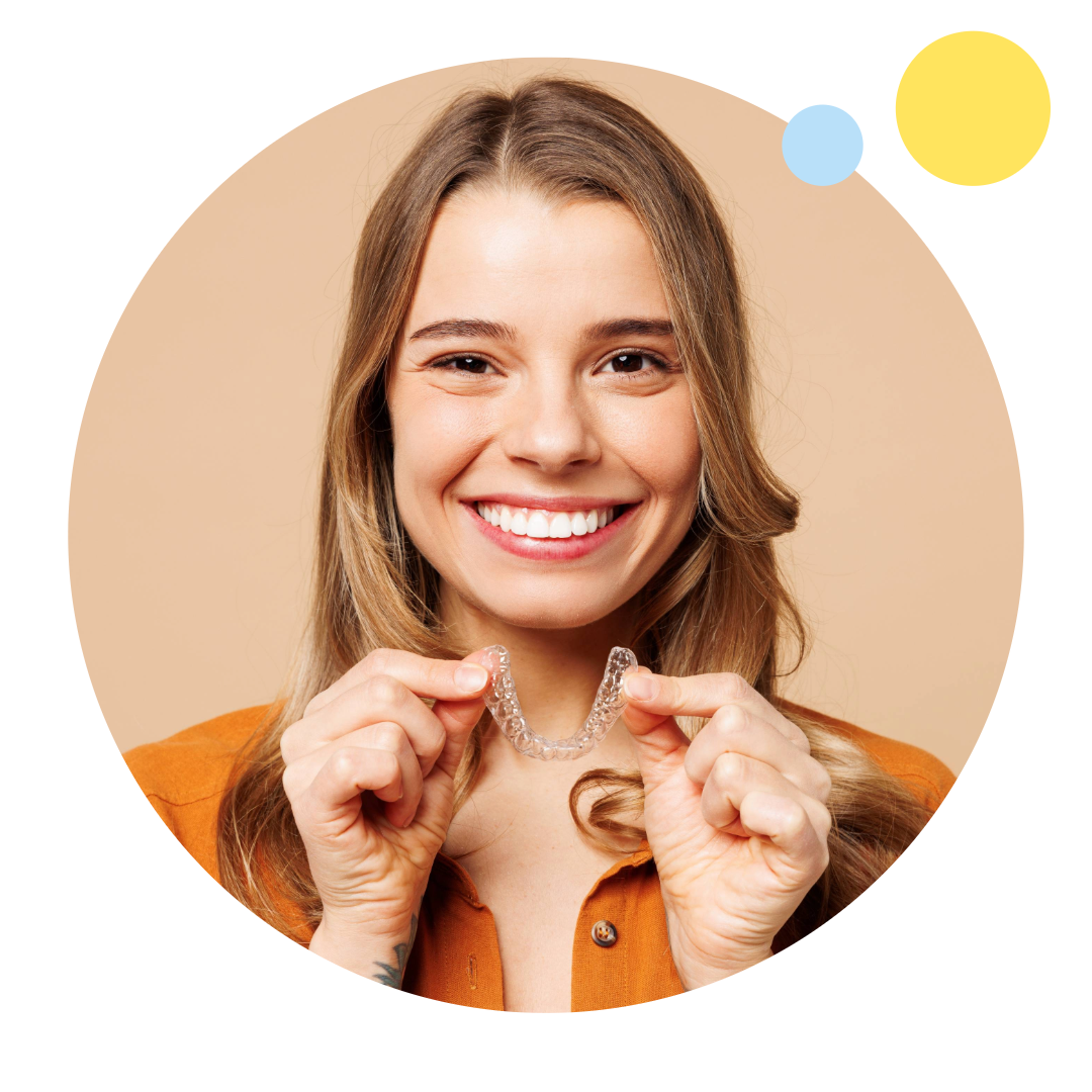 Lächelnde Frau mit Aligner in der Hand