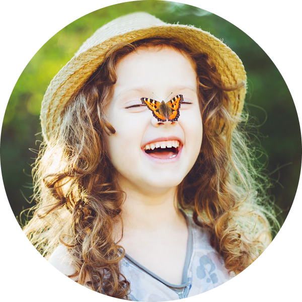 Ein lachendes Mädchen mit einem Schmetterling auf der Nase