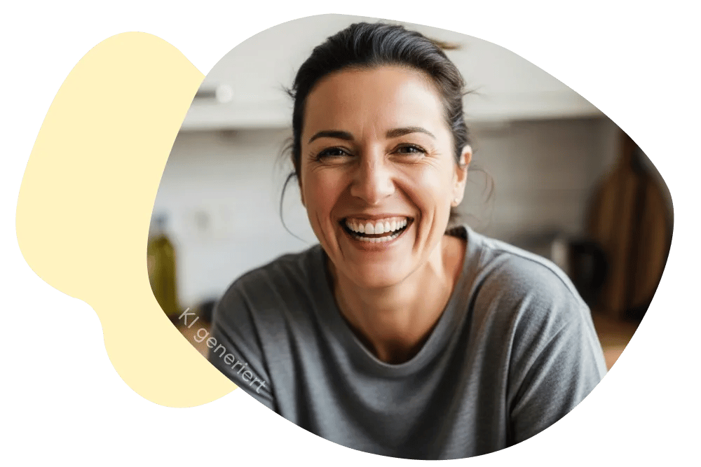 Eine Frau sitzt in der Küche und lacht, man sieht ihre schönen Zähne, im Kontext Zahnzusatzversicherung mit Soforthilfe von DA Direkt