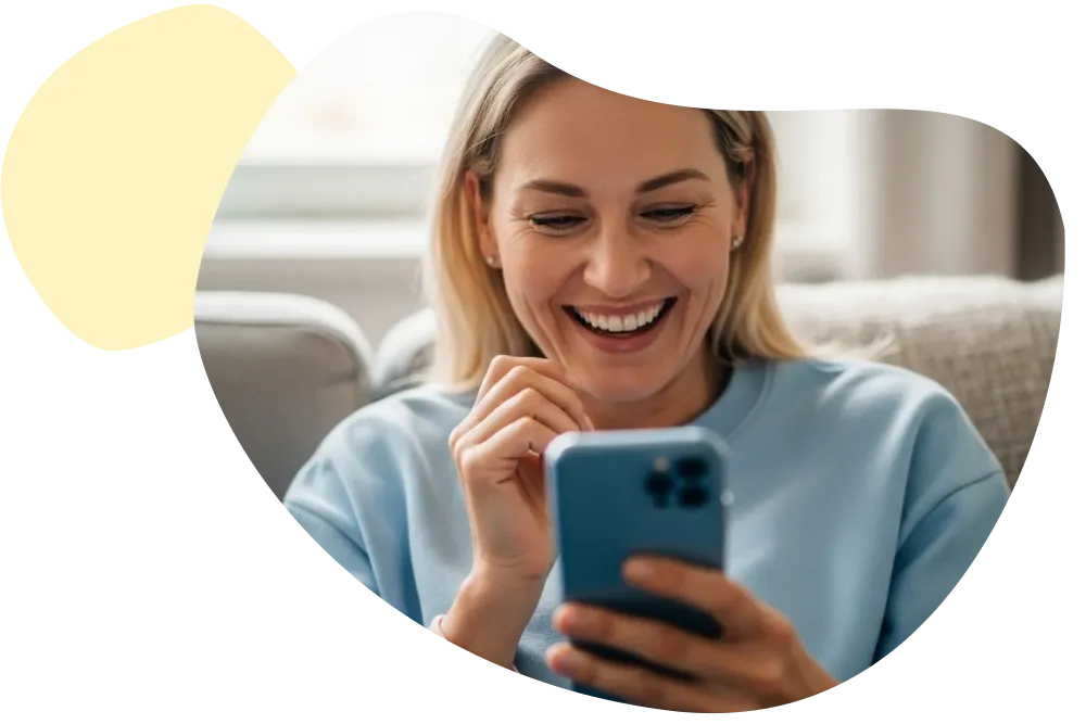 Ihr Kundenkonto zu Ihrer Zahnzusatzversicherung Lachende Frau tippt lächelnd auf ihrem Smartphone