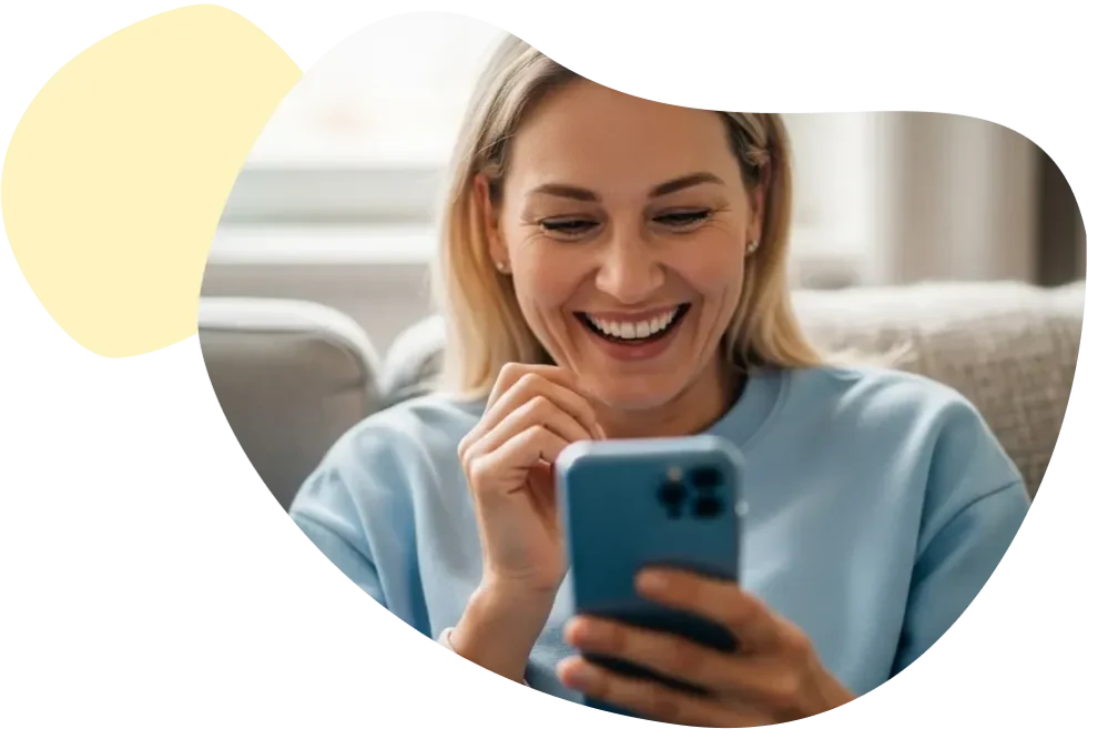 Ihr Kundenkonto zu Ihrer Zahnzusatzversicherung Lachende Frau tippt lächelnd auf ihrem Smartphone